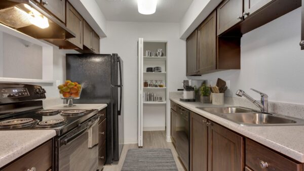 kitchen with dark brown cabinets, black appliances, and pantry