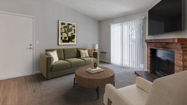 living room with fireplace, couched, coffee table, and window to balcony