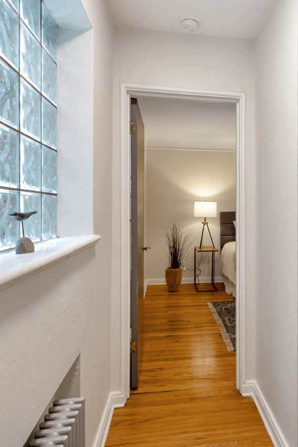 hallway with glass window to the left and bedroom entrance to the right