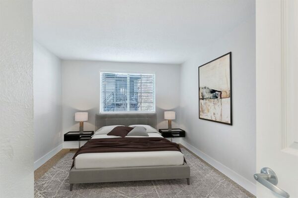 Rendering of a bedroom with tan carpet, white walls, and a large window.