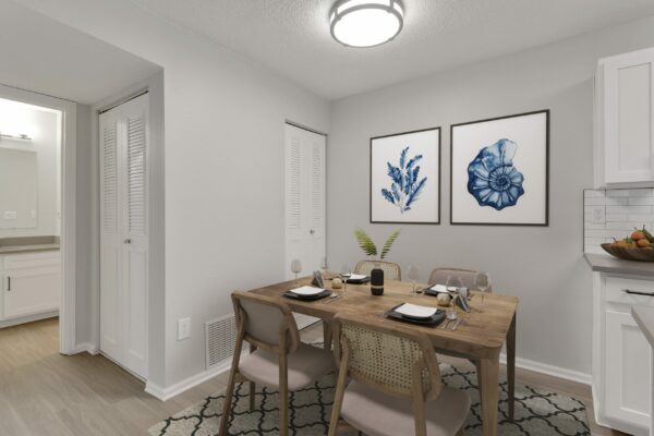 Kitchen with wood floor, wood dining table with chairs, and framed artwork.