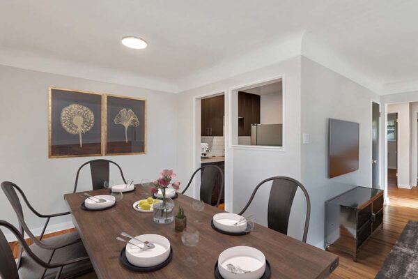 Furnished dining room with artwork and white walls.