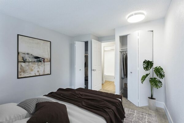 Bedroom with two closets, white walls, and a large plant.