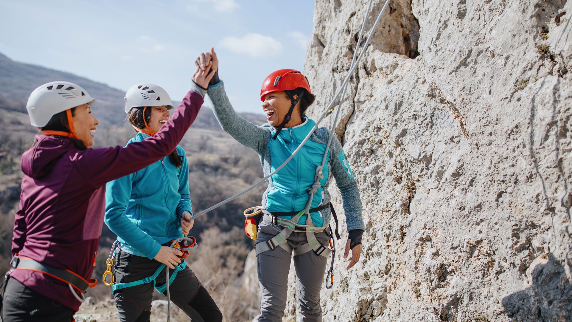 Friends celebrating together while rock climbing.
