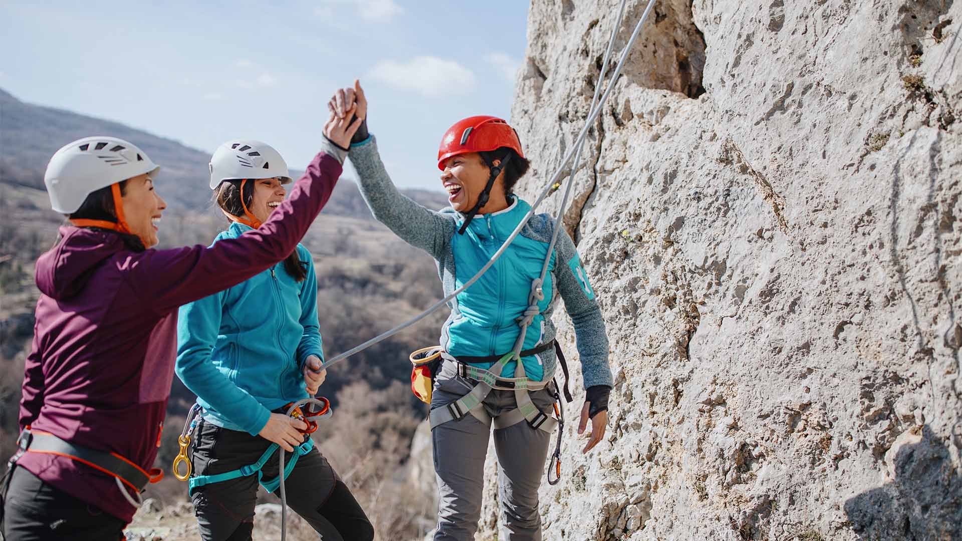 Friends celebrating together while rock climbing.