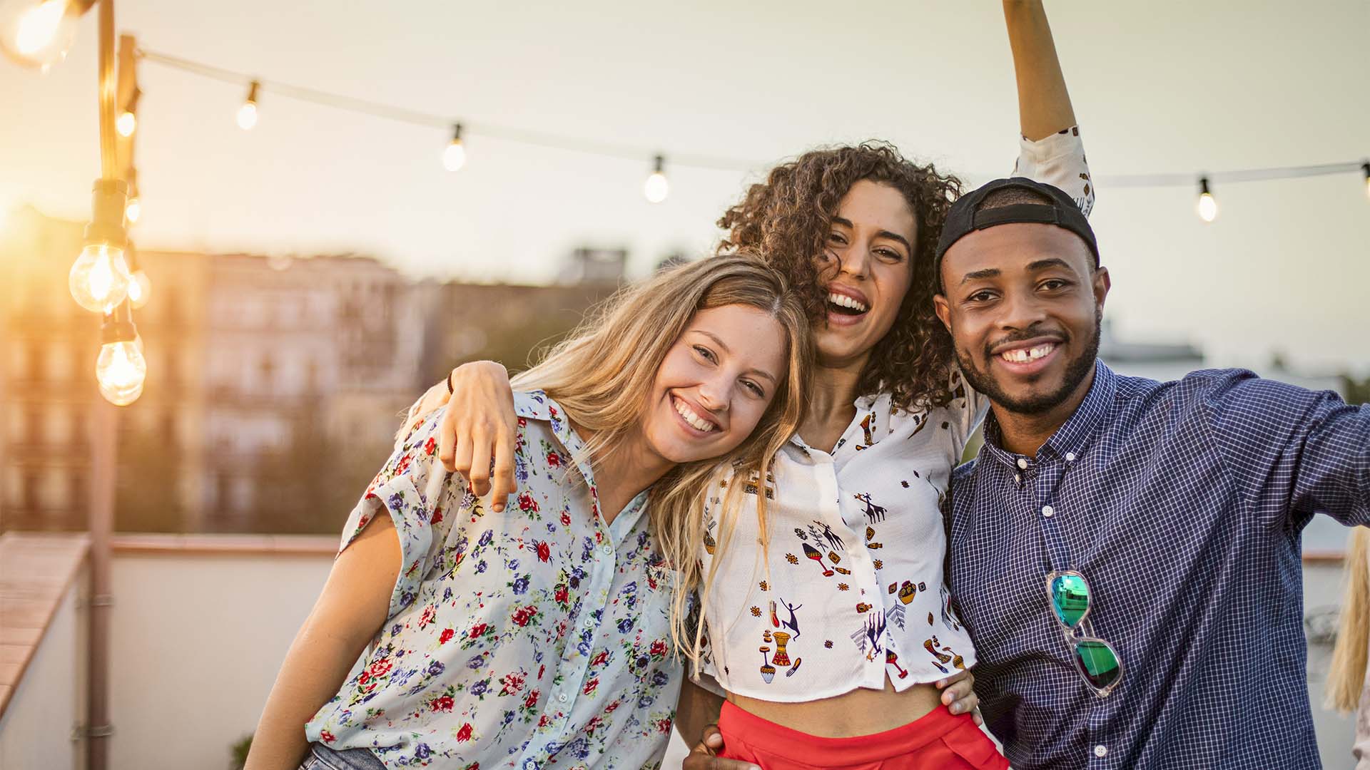Friends smiling and posing together on rooftop patio.