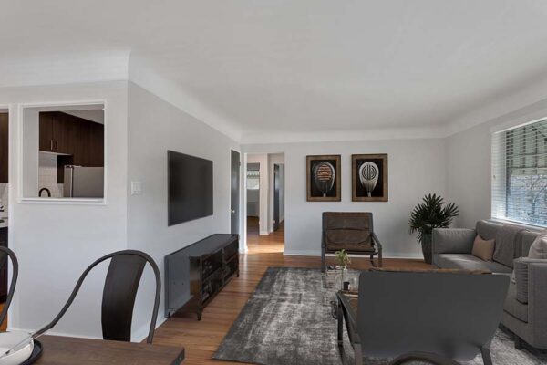 Furnished living room with white walls and carpet over wood floors.