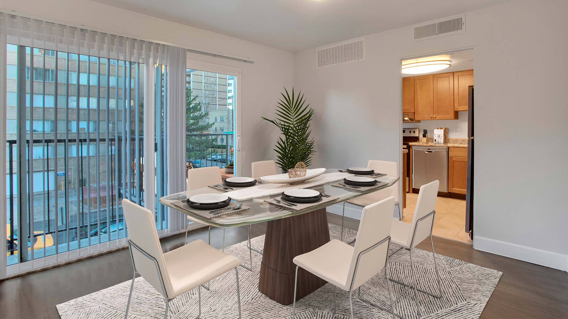 Furnished dining room with wood floors and white walls.