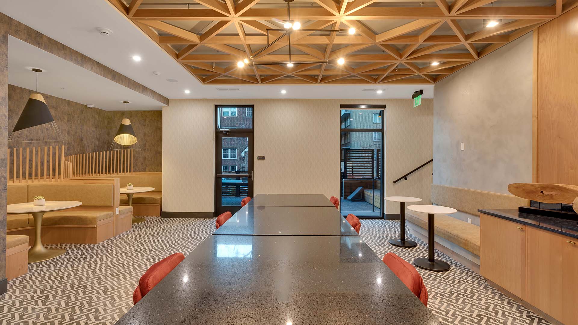 Shared workspace with a long conference table, white walls, and tile floor.