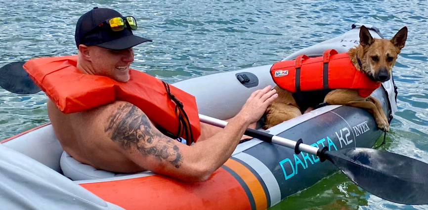 Person in inflatable kayak with dog.