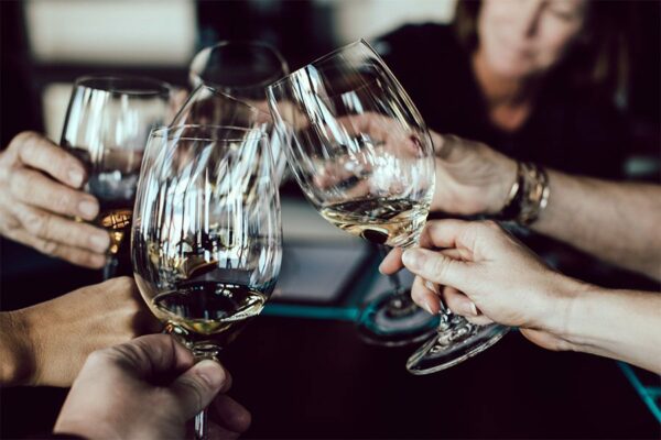 Six people toasting with wine glasses.