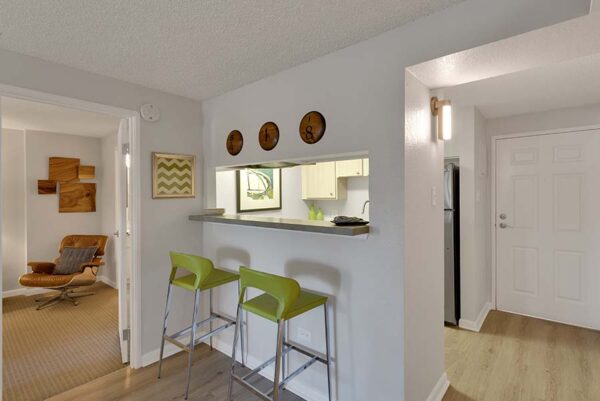 A kitchen with a bar area, with artwork, and bar stools.