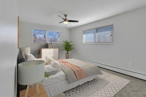Rendering of a furnished bedroom with gray carpet, white walls, and two windows.