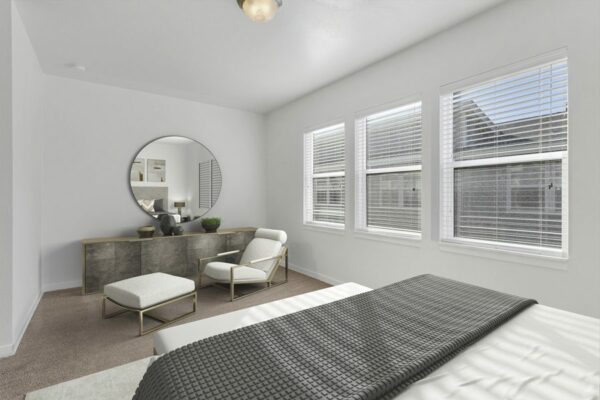 Rendering of a bedroom with a seating area, carpet, and white walls.