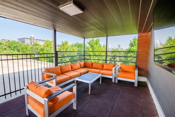 Rooftop patio with plush orange outdoor seats and TV.