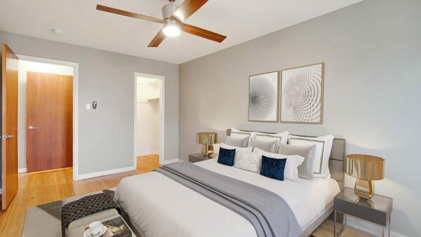 Bedroom with plush bed, dressing table, bedside tables with lamps, and artwork.