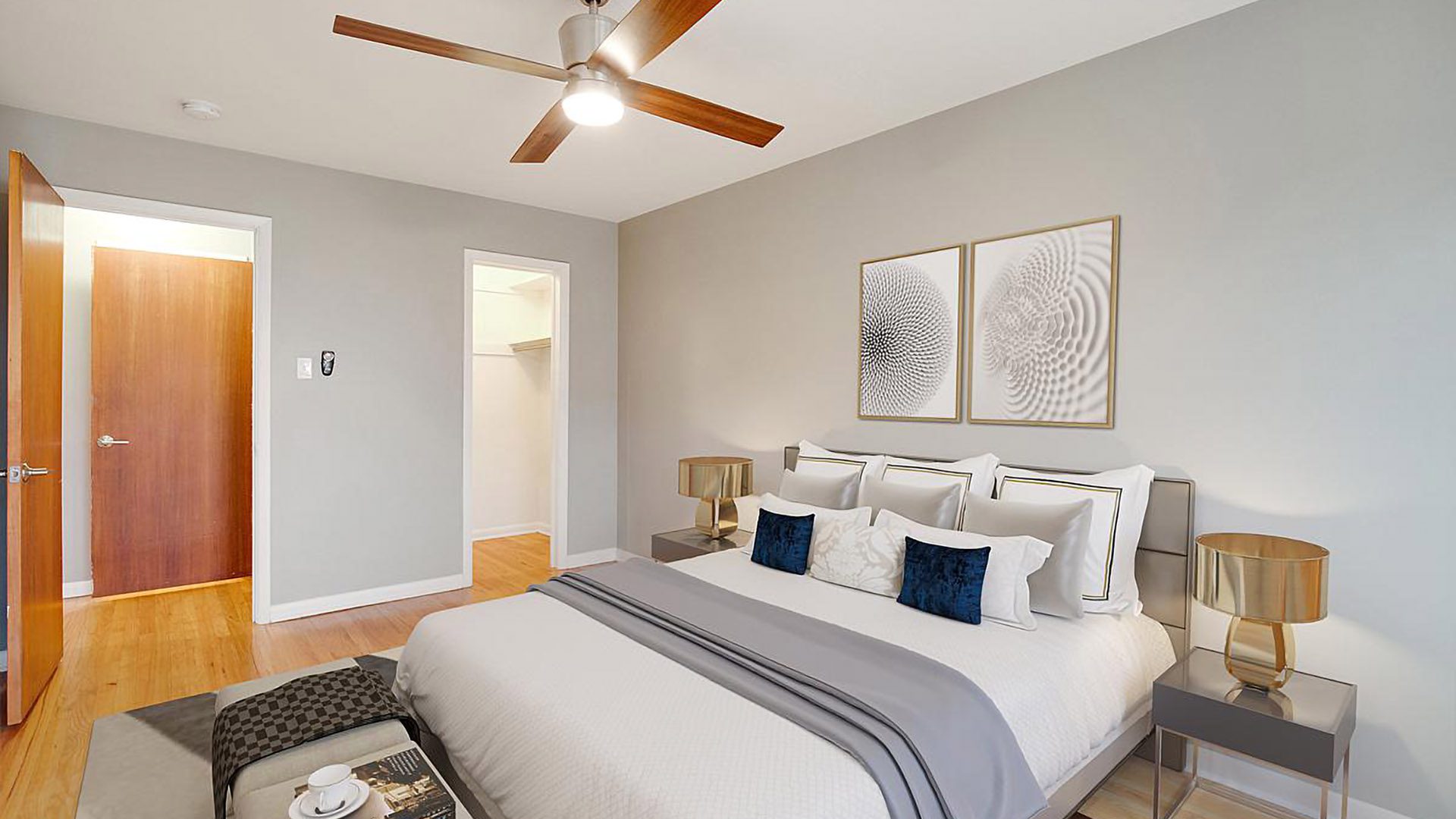 Bedroom with plush bed, dressing table, bedside tables with lamps, and artwork.