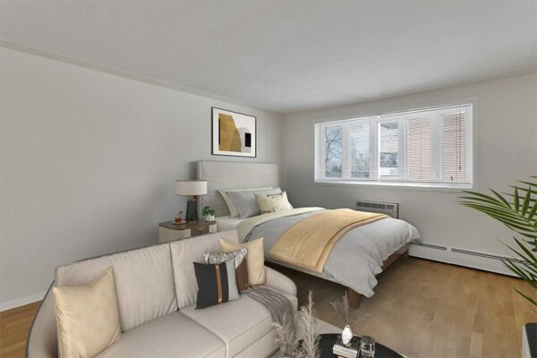 Rendering of a bedroom with wood floors, white walls, and a seating area.