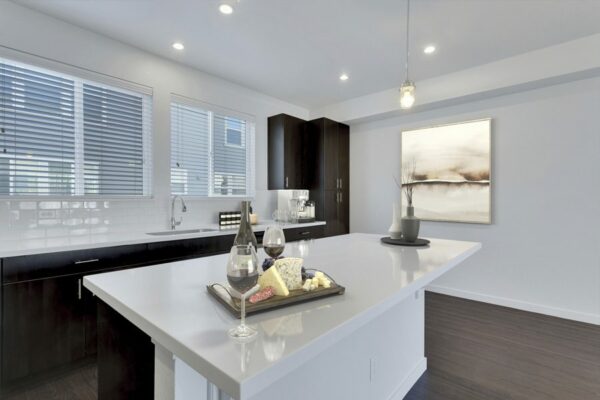 Rendering of a kitchen with a large island, dark wood cabinets, and white countertops.