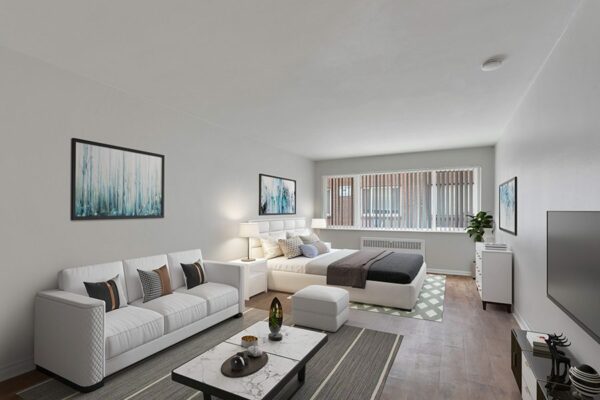 Studio living area with wood floor, plush bed, modern furnishings, and large window.