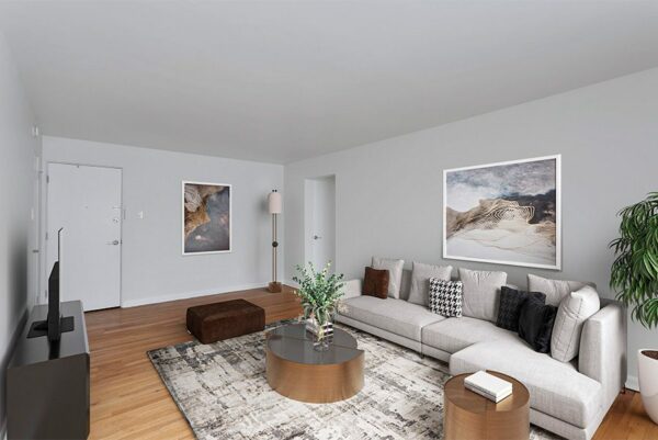 Living room with plush sectional, modern coffee tables, and framed art.