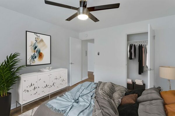 Bedroom with plush bed, dresser, framed art, and door to closet.