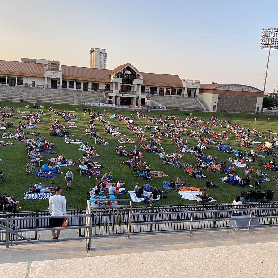 Sports field with people laying on blankets.