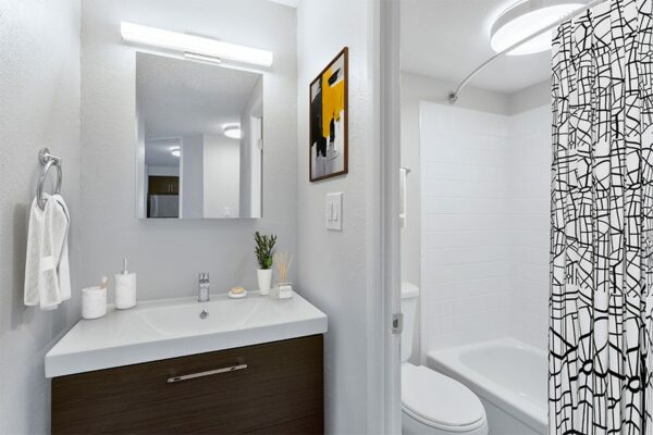 Bathroom with white countertops, dark wood cabinets, and a full-sized shower.