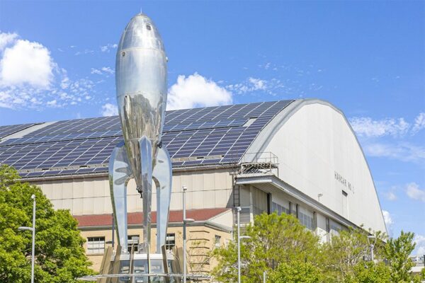 Large hangar with metal rocket ship in front in Lowry neighborhood.