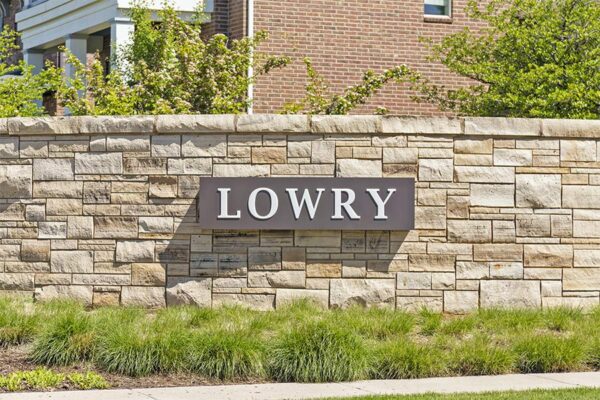 Metal Lowry sign on stone wall.