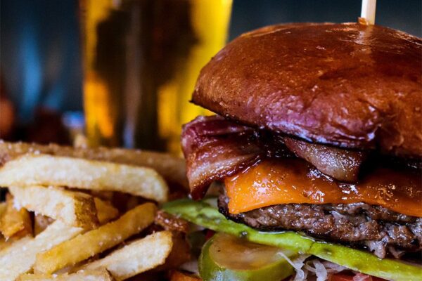 Detail of burger with bacon and french fries.