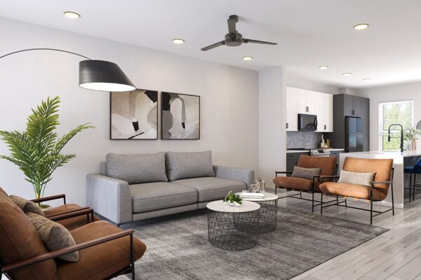 Living room with plush seating, framed artwork, large plant, and ceiling fan.
