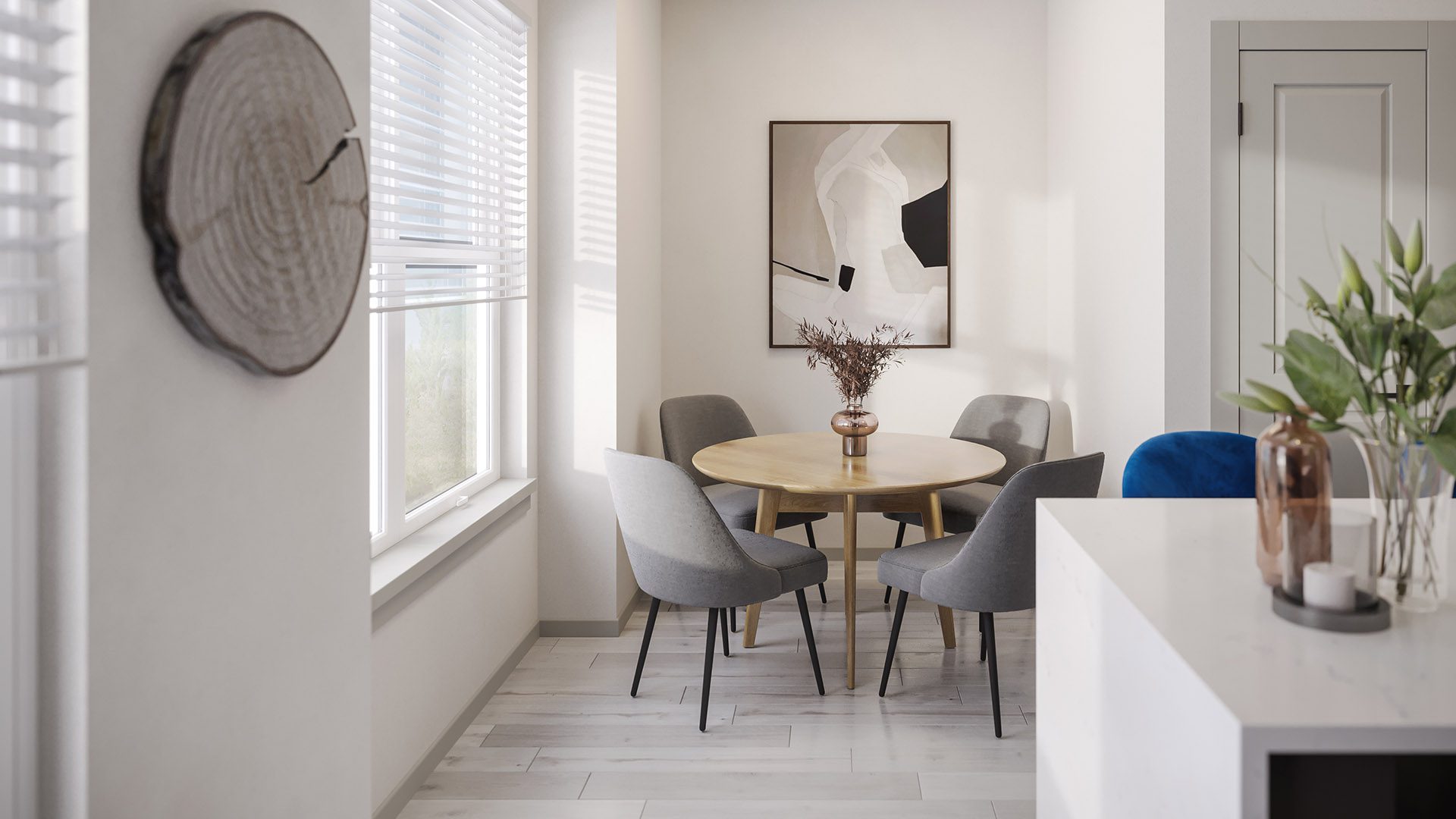 Dining area with round table, plush chairs, large window, and framed art.