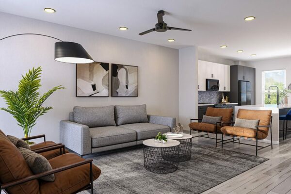 Living room with plush seating, framed artwork, large plant, and ceiling fan.