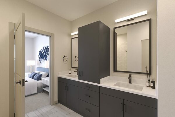 Bathroom with dark cabinets, light counters, and large framed mirrors.