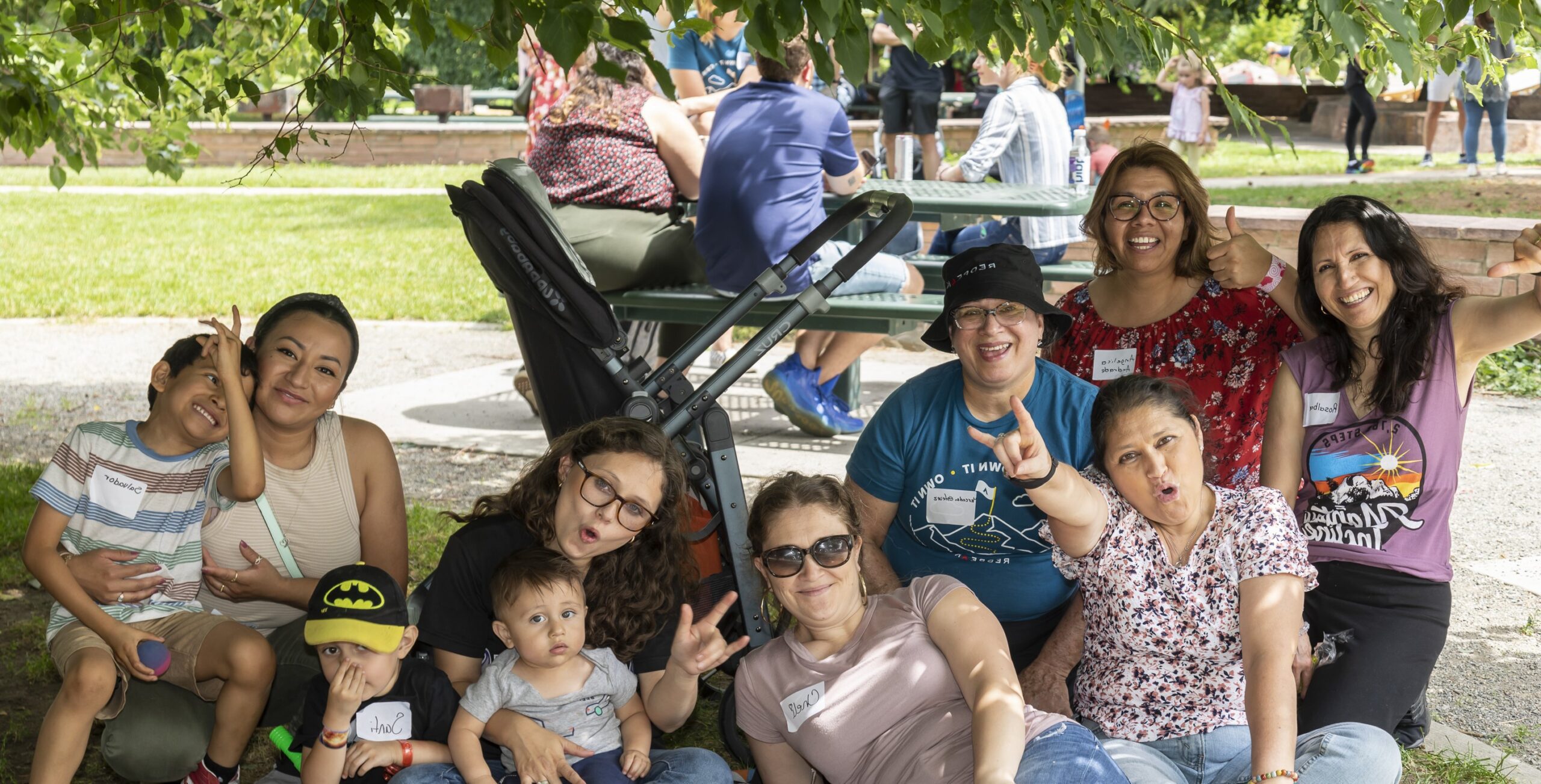 team members sitting on the grass at a company picnic event