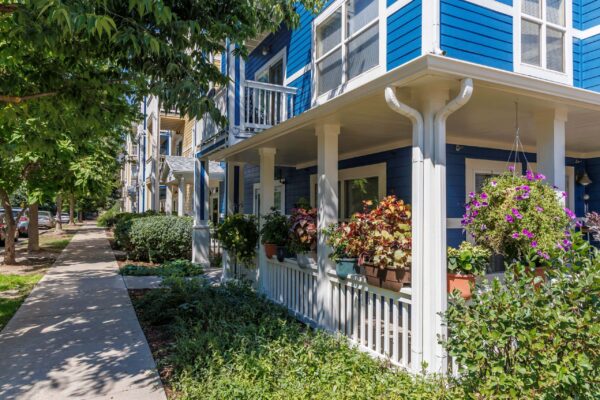 blue building with white trim and greenery surrounding