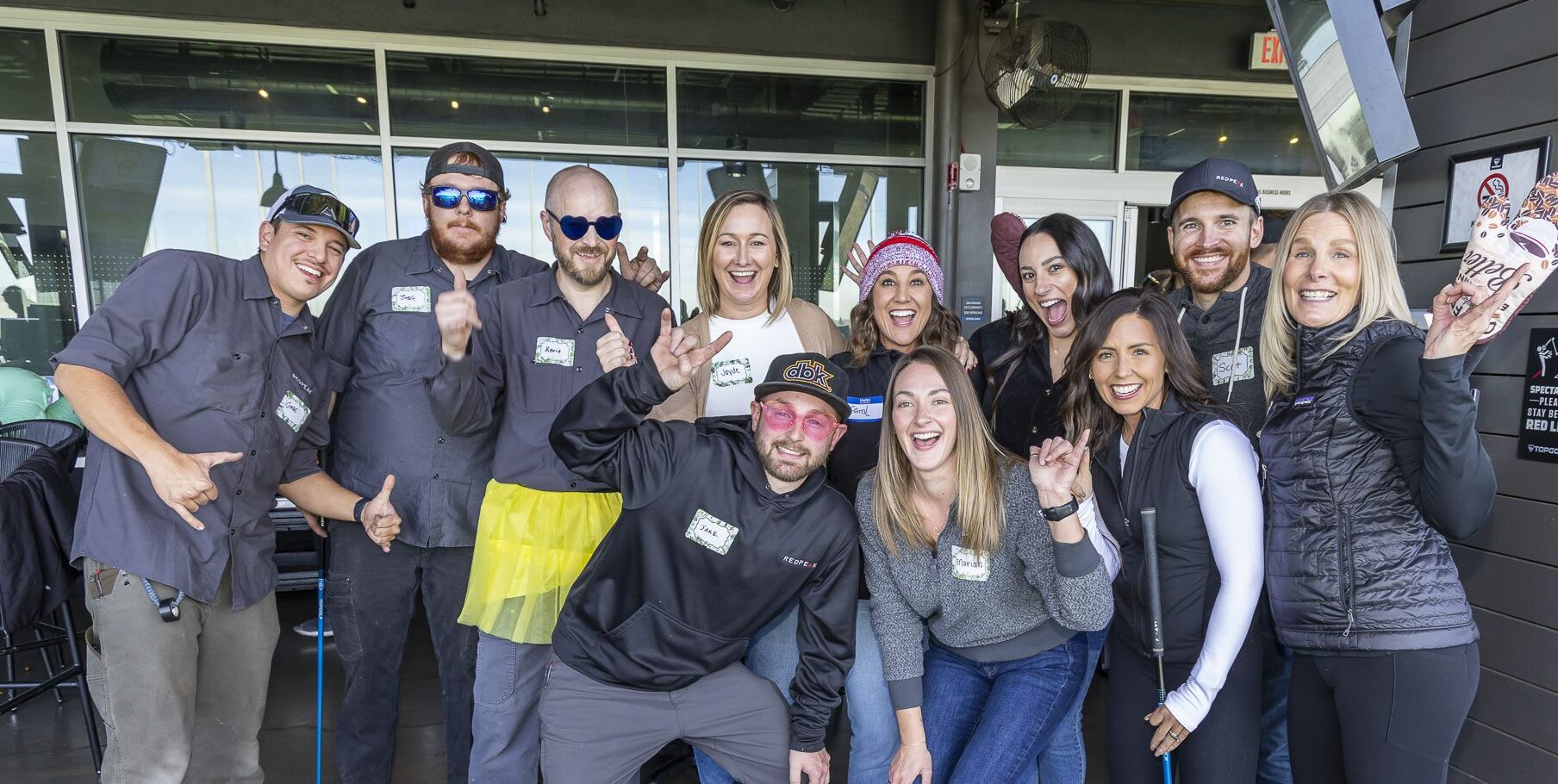 group of people posing at top golf for company event