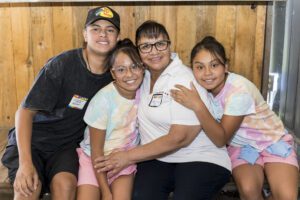 family of 4 posing for photo hugging