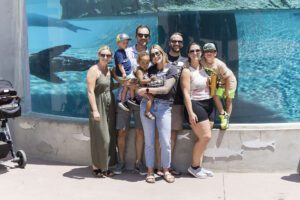 group of friends in front of the whale at the zoo