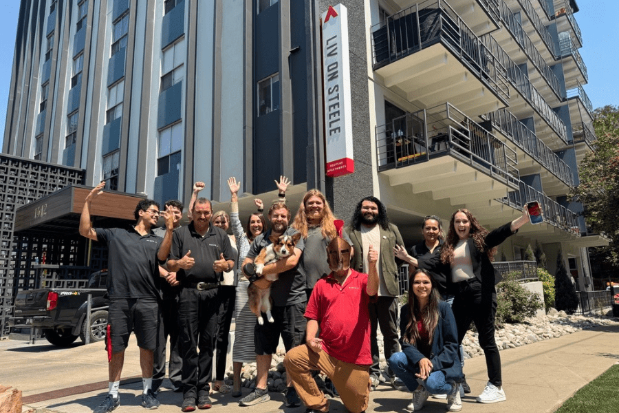 the team at Liv on Steele apartments posing in from of the apartment building after winning the Warrior Award